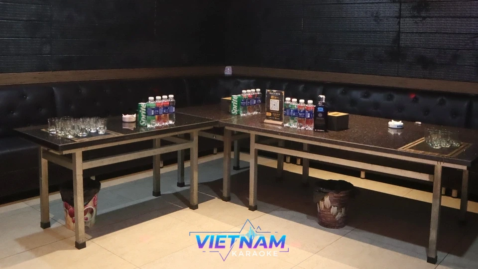 검은색 소파와 테이블이 있는 가라오케 룸